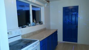 A kitchen with a stove, oven, and blue cabinets. - Wild Creek BnB, " Cottage " (Dyer)