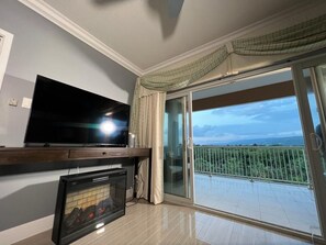 Relax in this stylish living room with a flat-screen TV, fireplace, and sliding glass door to a balcony with a view.