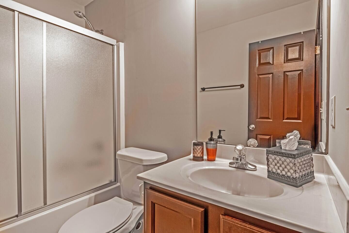 Une salle de bain équipée d’une douche, de toilettes, d’un lavabo et d’un miroir.