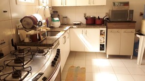 A kitchen with a gas stove, microwave, and cabinets.