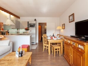 A modern apartment with a kitchen, dining area, and living room.