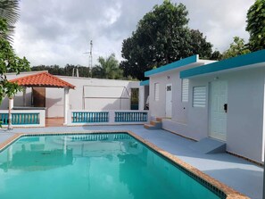 Relax by the pool in a tranquil setting surrounded by lush greenery.