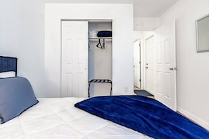A bedroom with a bed, a wardrobe, and a door leading to another room. - Stunning Pool Home, Near Siesta Key & Dog Friendly (Sarasota)