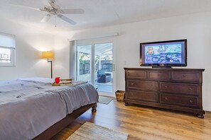 A bedroom with a bed, a dresser, a television, and a ceiling fan. - Stunning Pool Home, Near Siesta Key & Dog Friendly (Sarasota)