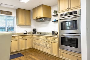A kitchen with wooden cabinets, a stainless steel range, and an oven. - Stunning Pool Home, Near Siesta Key & Dog Friendly (Sarasota)