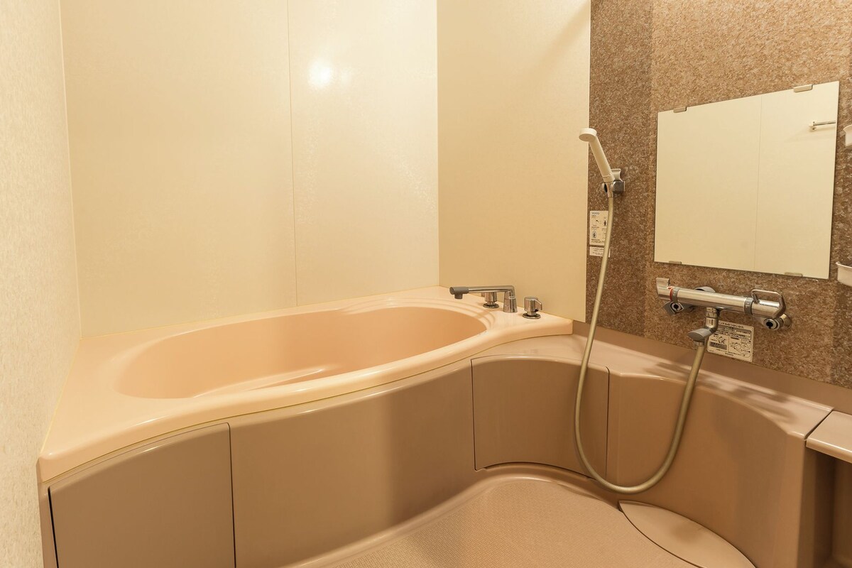 Un baño con bañera, ducha y espejo.