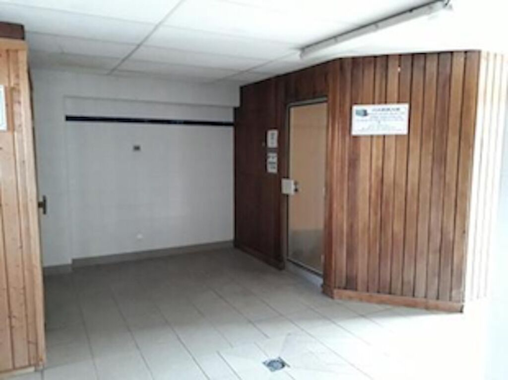 A hallway with a wooden door and a sign on the wall.
