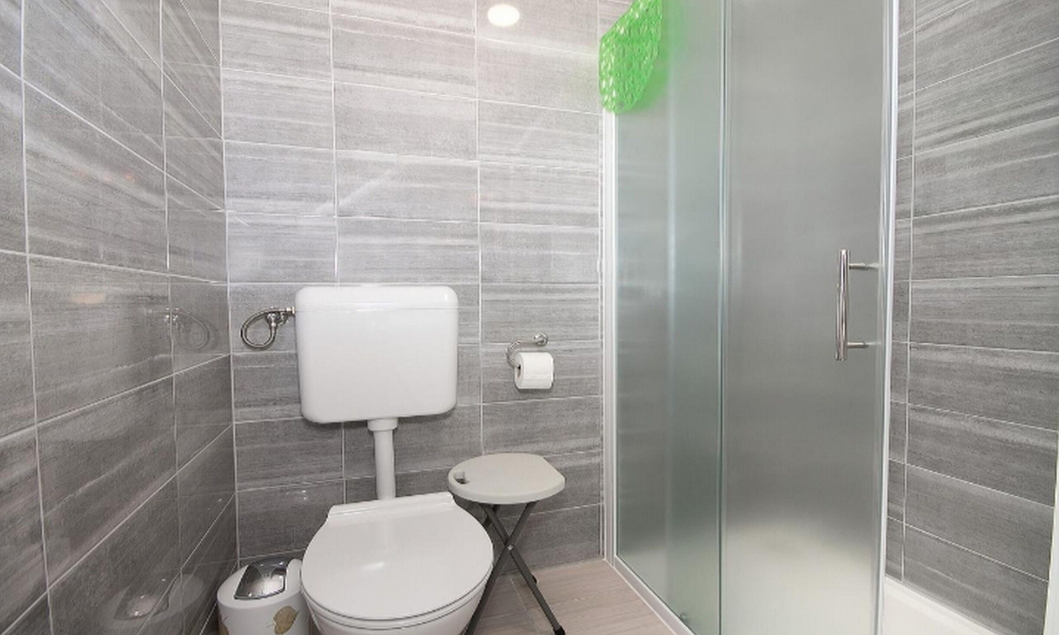 Een moderne badkamer met toilet, bidet en douchecabine van glas.