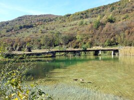 Un río cristalino con un puente y colinas circundantes.