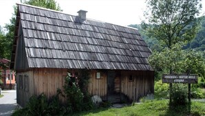 A rustic wooden building with a weathered roof, surrounded by greenery and a sign indicating it is the Vodenica Water Mill in Koran. - Apartment Josipa (Rakovica)