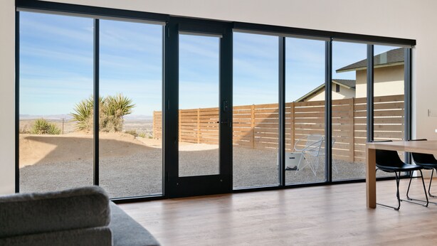A modern interior with a large sliding glass door leading to an outdoor patio area. - Back Haus - Views, Dark Skies and Fire Pit! (Joshua Tree)