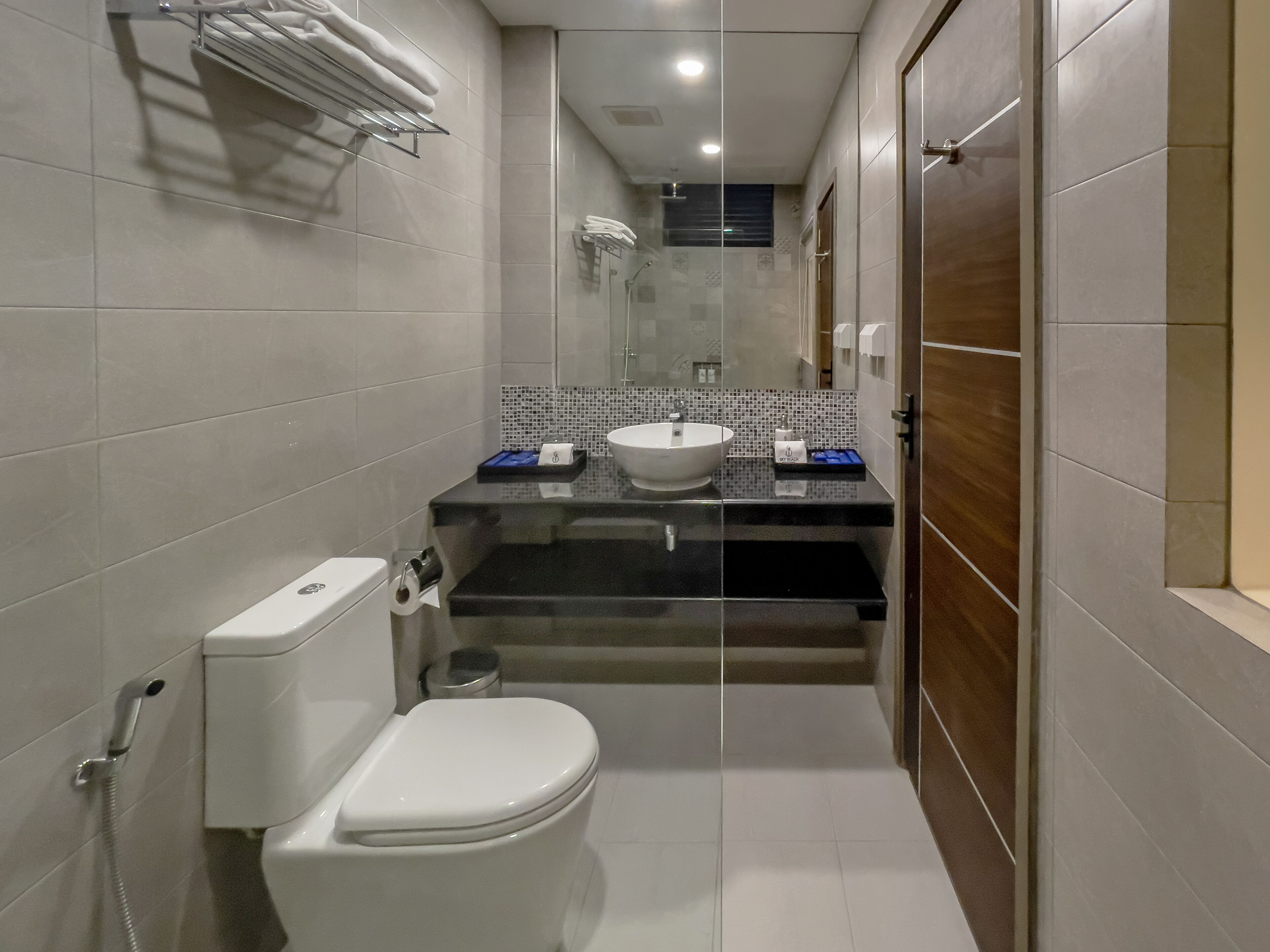 A compact bathroom with a toilet, sink, and shower.