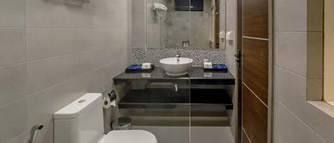 A compact bathroom with a toilet, sink, and shower.