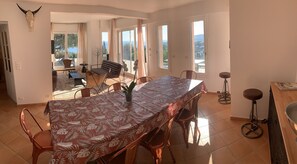 Enjoy meals in this dining area with a long table, large windows, and a unique bull's skull decoration.