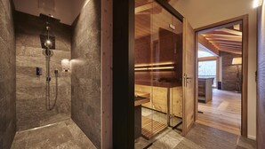 Une salle de bain moderne dotée d’une douche à parois de verre, d’éléments décoratifs en bois et offrant une vue sur l’espace de vie adjacent.