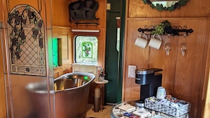A compact RV bathroom with a bathtub, sink, and a small refrigerator. - Grape Escape at Olympic Railway Inn - Pet Friendly (Sequim)
