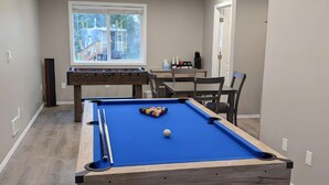 A pool table in a room with a window, a coffee machine, and a door. - Steampunk Train at Olympic Railway Inn - Pet Friendly (Sequim)