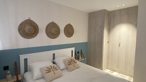 Une chambre à coucher avec un lit, une table de chevet et une armoire.
