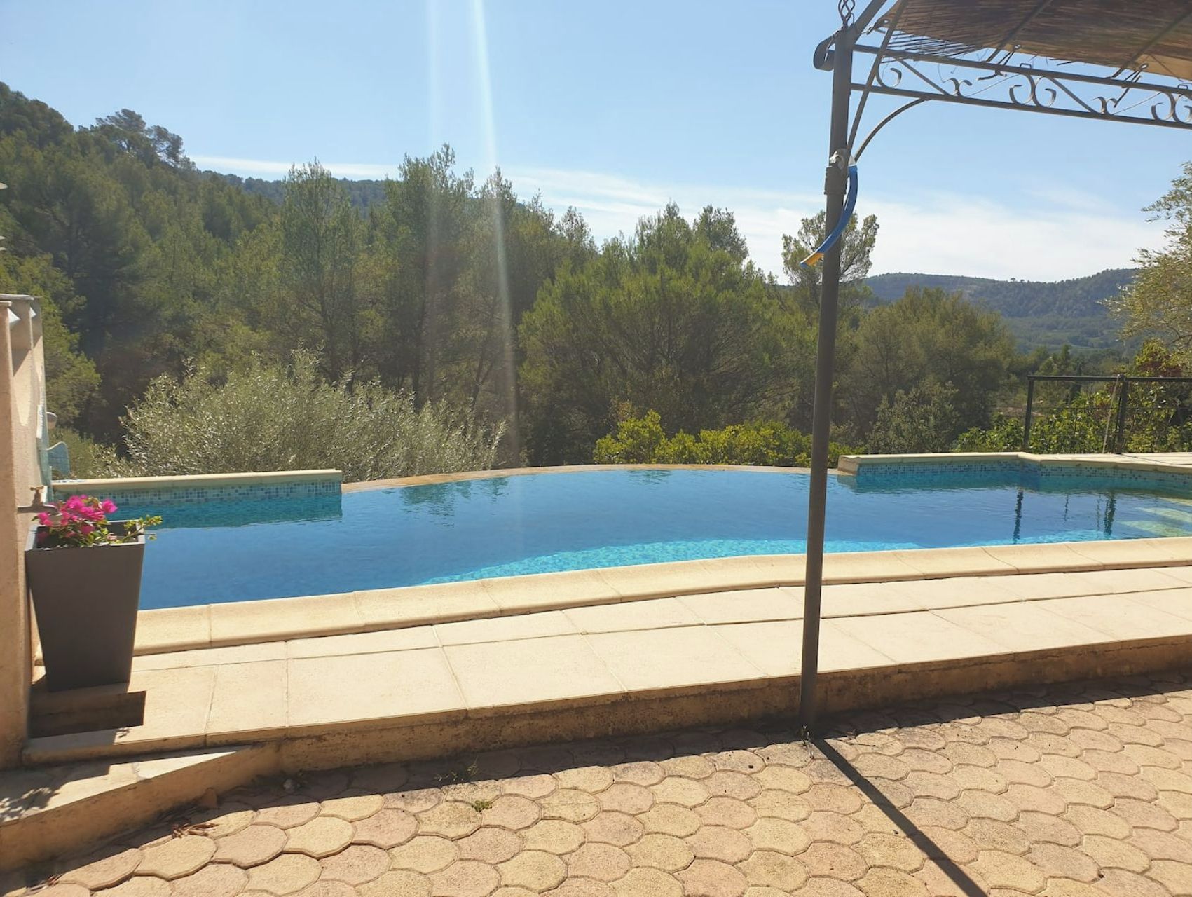 A swimming pool with a view of a forested hillside.