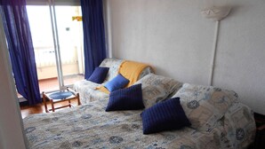 Une chambre avec un lit, une chaise et une vue sur l’extérieur.