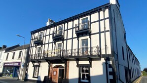 A two-story building with a white facade and black trim, featuring a sign for 'Kings Arms Hotel'. - The Kings Arms Hotel (Lockerbie)