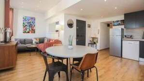 Eine moderne Wohnung mit Wohnzimmer, Essbereich, Küche und einem großen Fenster.