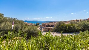 A coastal view with buildings, a clear sky, and greenery. - Villetta Franca 100m From The Beach (Golfo Aranci)