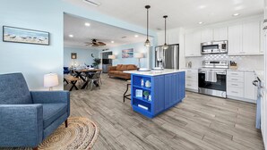 A modern kitchen with white cabinets, stainless steel appliances, and a blue island. - ⚓Private pool home-Boat Dock-Arcade Games!⚓🌅 (Bradenton)