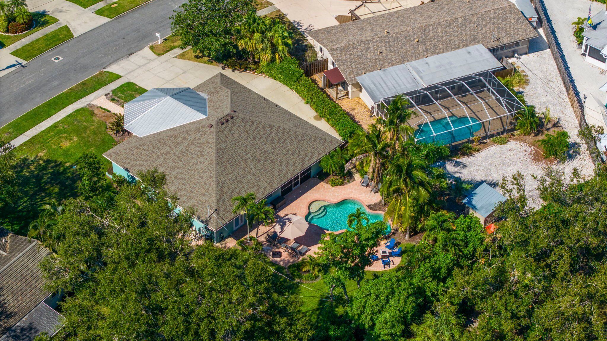 A residential property with a swimming pool, a covered patio, and a fenced yard.