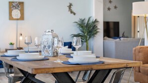 A dining table set with white plates, blue placemats, and clear glassware. - ⚓Private pool home-Boat Dock-Arcade Games!⚓🌅 (Bradenton)