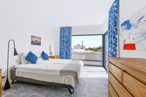 A bedroom with a bed, bedside lamps, a wooden dresser, and a view of the outdoors. - Casa Blanca Magnificent Villa With Modern Design, walking distance to beach (Carvoeiro)