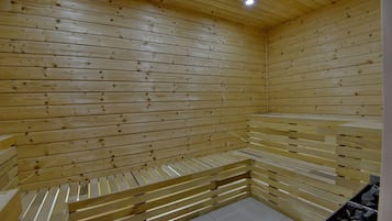 Un cuarto de sauna con paredes y bancos de madera.