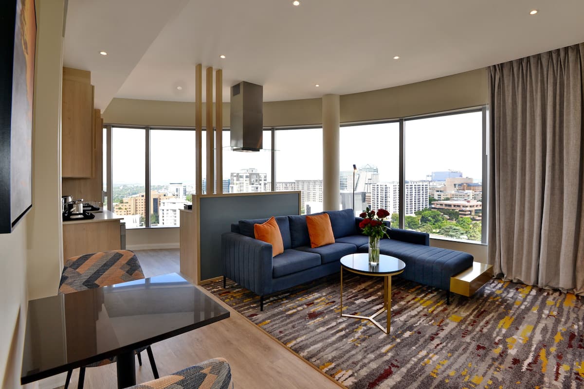 Een moderne woonkamer met een bank, een salontafel en uitzicht op de stad.