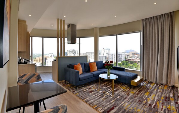 A modern living room with a sofa, a coffee table, and a view of the city.