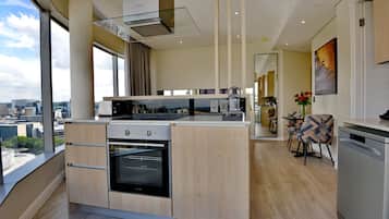 Una cocina moderna con horno empotrado, un ventanal y vista a la ciudad.