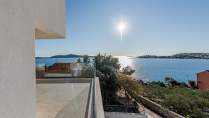 A modern building with a balcony overlooking a calm sea and distant hills. - Sea Bliss Luxury Villa - Sevid (Marina)