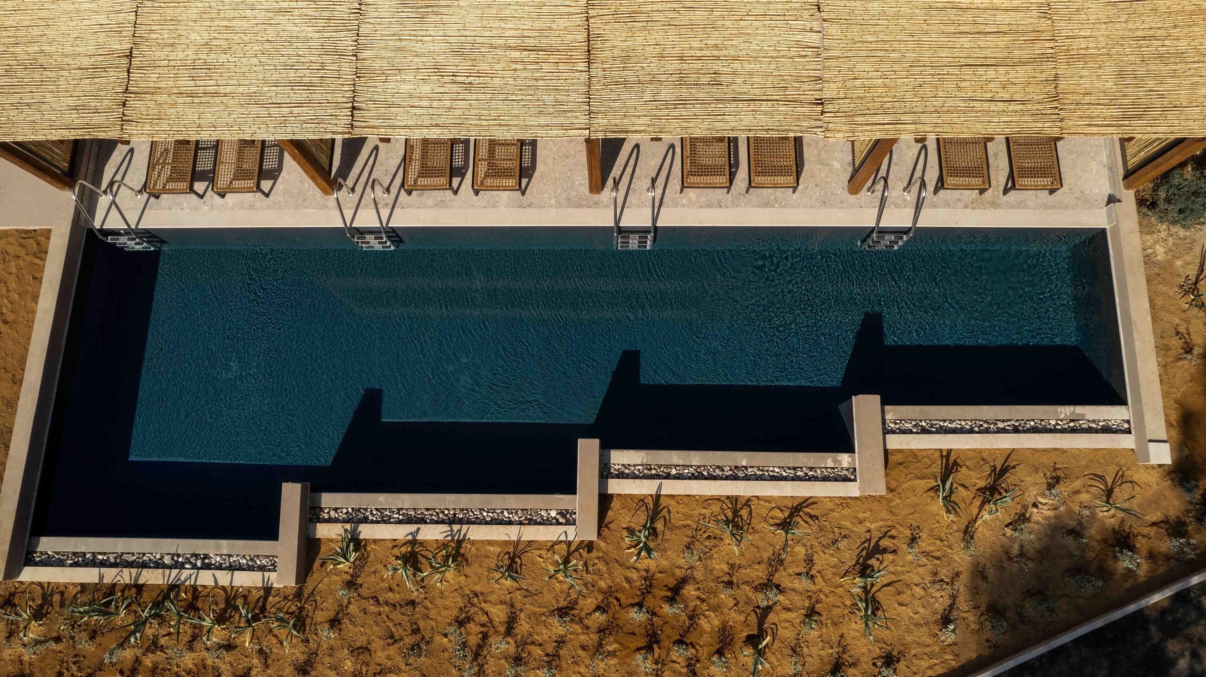 Vista aérea de una piscina rectangular con varias plataformas de salto y escaleras.