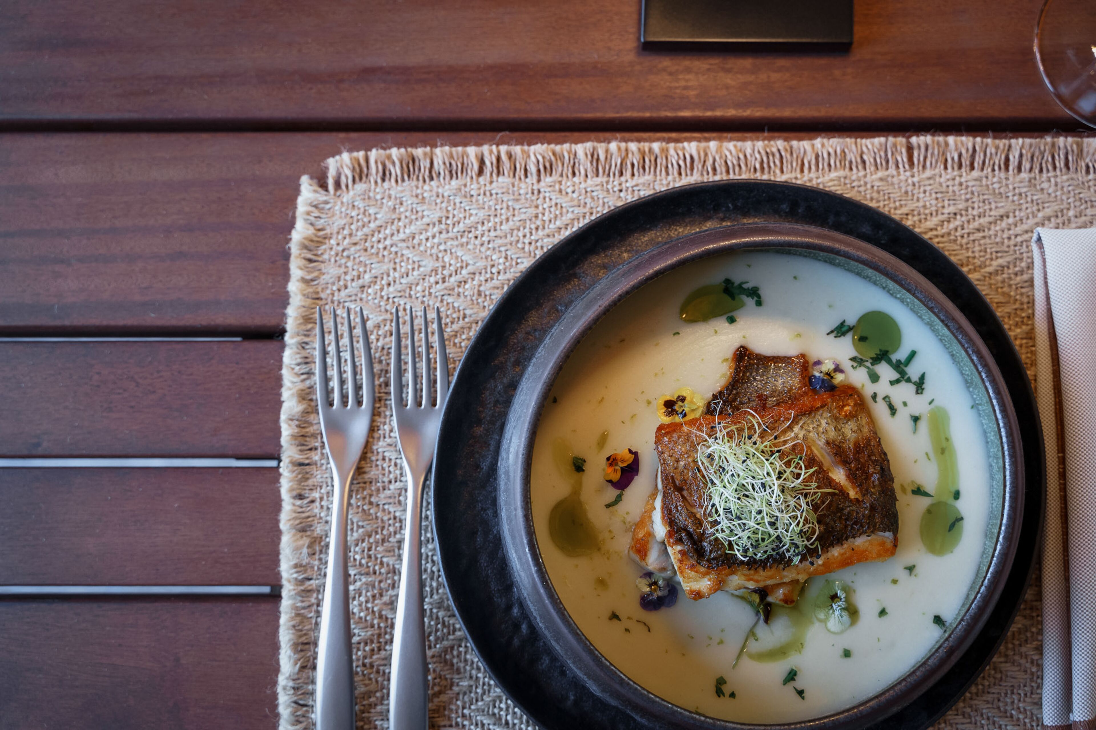 A plate of food with a fork and napkin on a table.