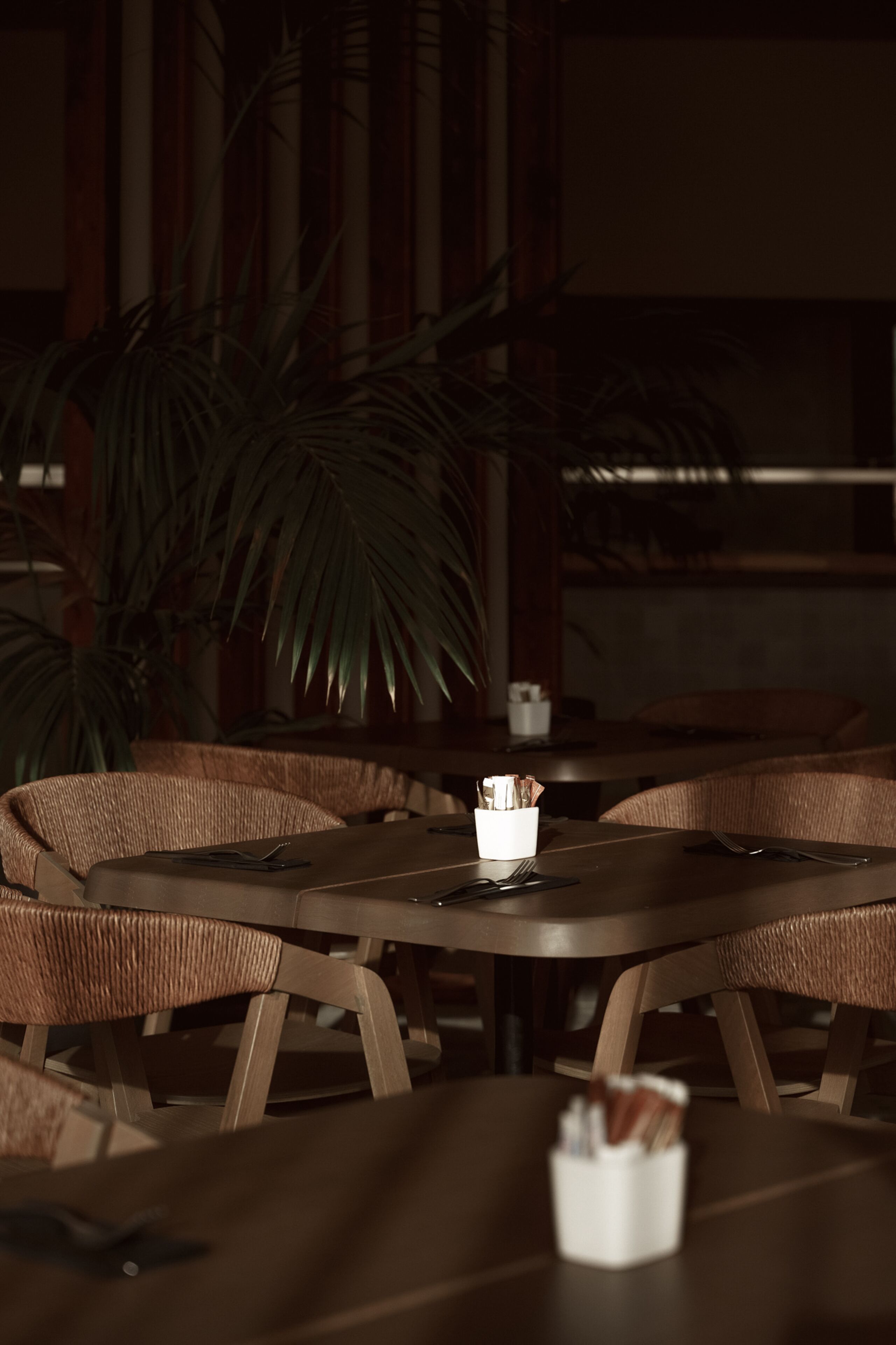 Uma sala de jantar com mobiliário de vime e uma mesa com vela.