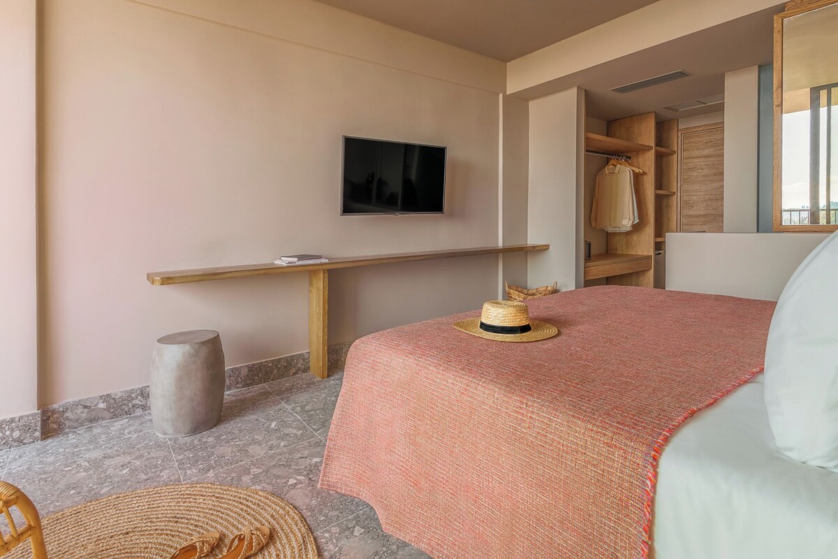 A room with a bed, a television, a wooden shelf, and a closet.