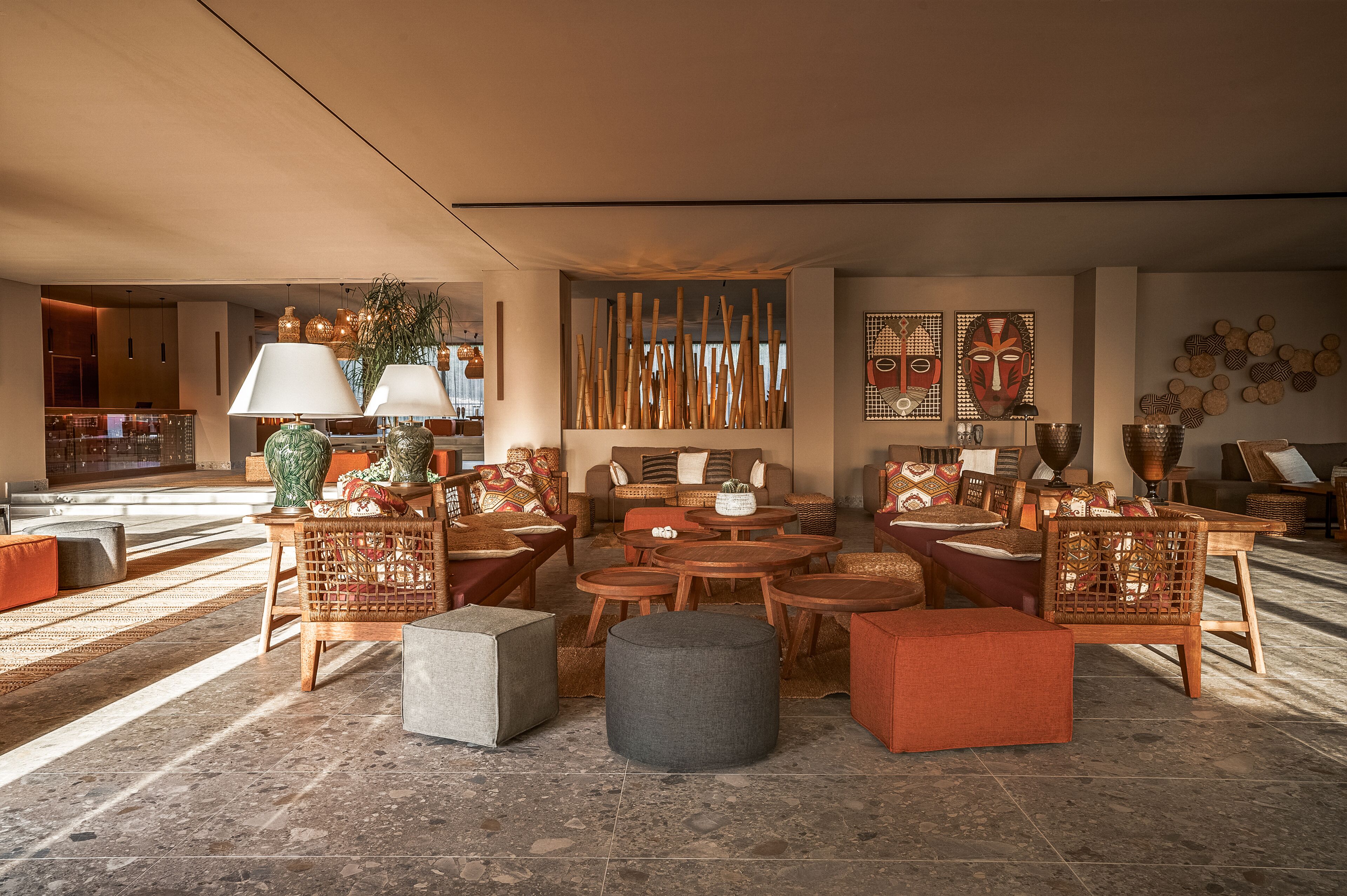 Un vestíbulo amplio con diversas opciones de asientos, incluyendo sofás, sillones y otomanas, dispuestos alrededor de una mesa de centro.