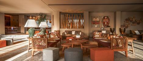 A spacious lobby with a variety of seating options, including sofas, chairs, and ottomans, arranged around a central coffee table.