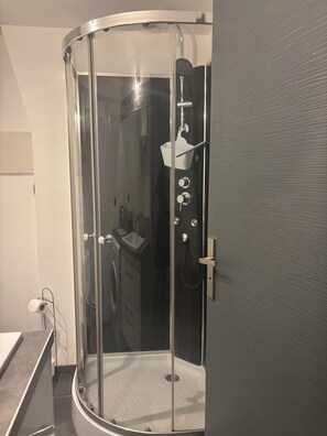 A modern bathroom with a glass-enclosed shower, a sink, and a toilet. - Charming, renovated studio apartment in Toulouse, in a beautiful location (Toulouse)