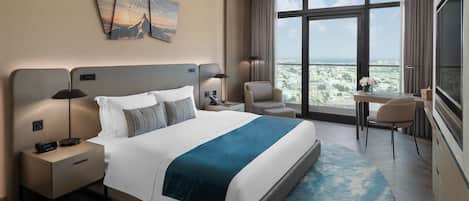 A modern hotel room with a large bed, a desk, a chair, and a view of the city.