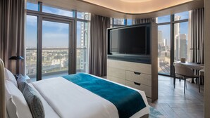 Habitación de hotel moderna con una cama grande, un televisor de pantalla plana, un escritorio y vistas a la ciudad.