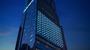Un edificio de gran altura con señalización iluminada, incluyendo 