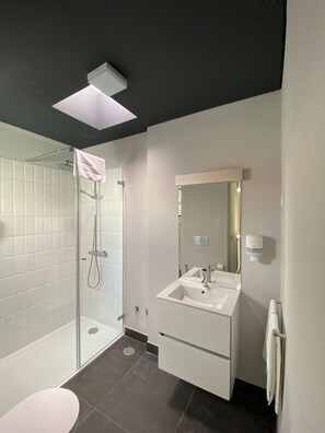 Habitación estándar con 2 camas individuales | Baño | Regadera, regadera tipo lluvia, secadora de cabello, toallas 