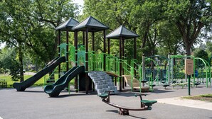 A playground with slides, climbing structures, and exercise equipment. - Historic Mc Kennan Park Apt 2 (1 bed 1 bath) - KP220APT2 (Sioux Falls)