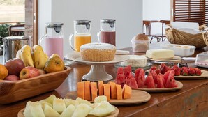 Un bufé de desayuno con diversas frutas, quesos y bebidas.