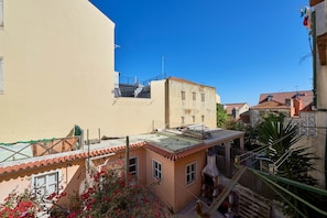Residential building with a flat roof and attached structure, set amidst a densely populated neighborhood.